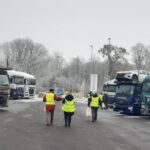 Berater laufen zwischen LKWs auf Parkplatz