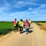 Vier Berater und Beraterinnen sind von hinten auf einem Feldweg zu sehen.